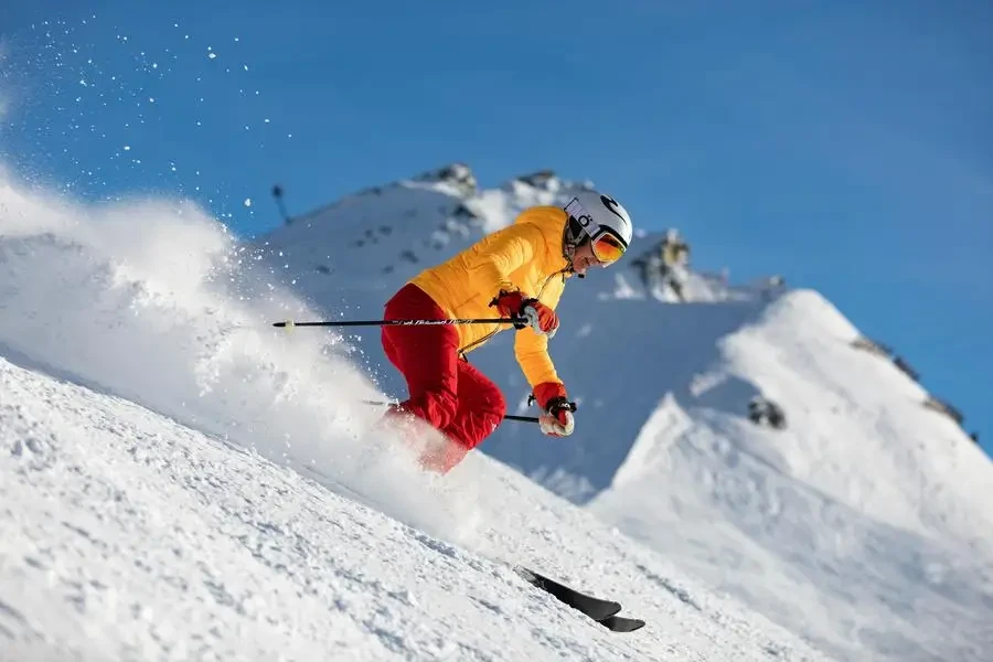 Dynamic capture of a skier racing downhill in snowy mountains, showcasing adrenaline and winter sport excitement