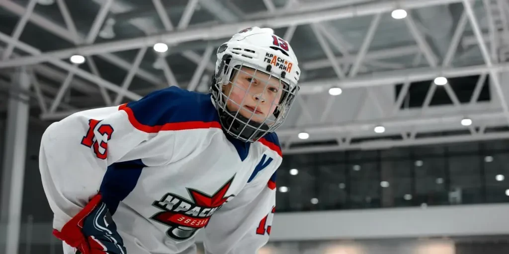 Dynamic shot of a young ice hockey player in full gear on an indoor rink, ready to play