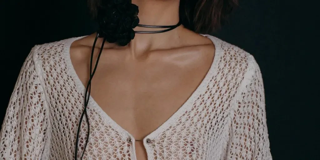 Elegant portrait of a woman wearing a white crochet top, captured in a studio setting