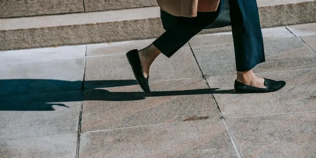 Elegantly dressed woman walking on a city sidewalk in fall