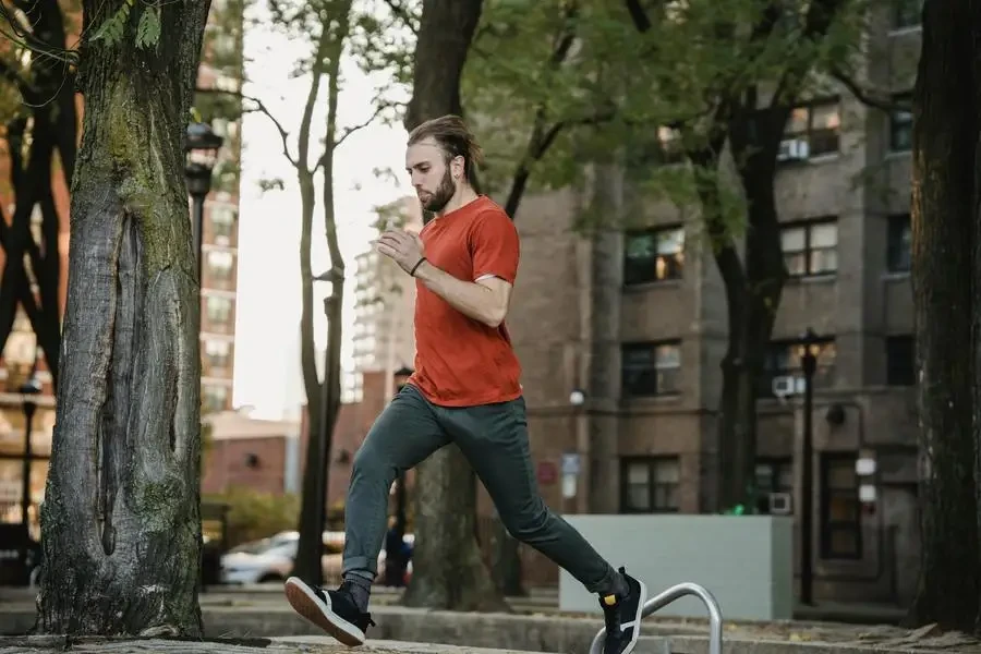 Energetic young man practicing parkour outdoors in a city park, showcasing agility and focus