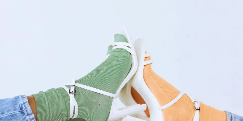 Fashionable studio shot of colorful socks paired with white heels for a modern look