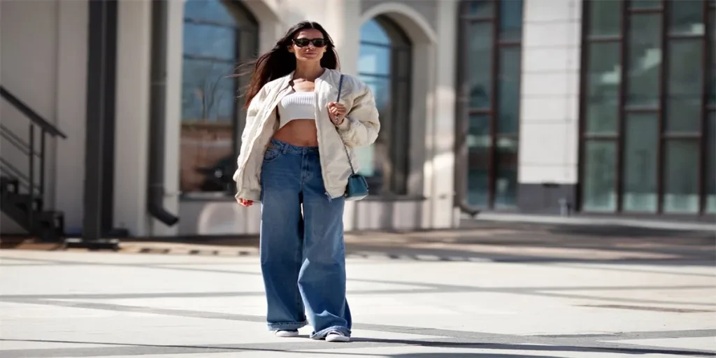 Fashionable woman with long flowing hair wearing trendy white bomber jacket