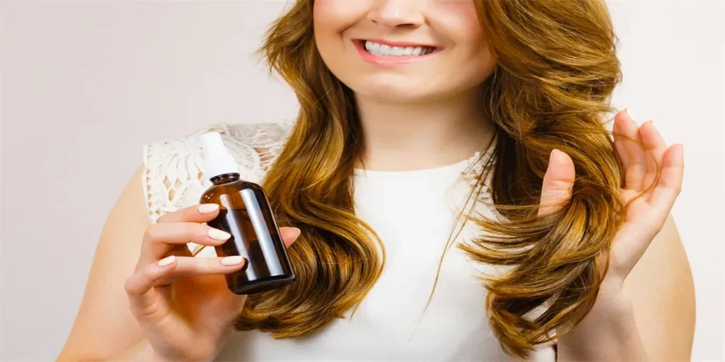 Female model with shiny wavy brown long hair using cosmetic