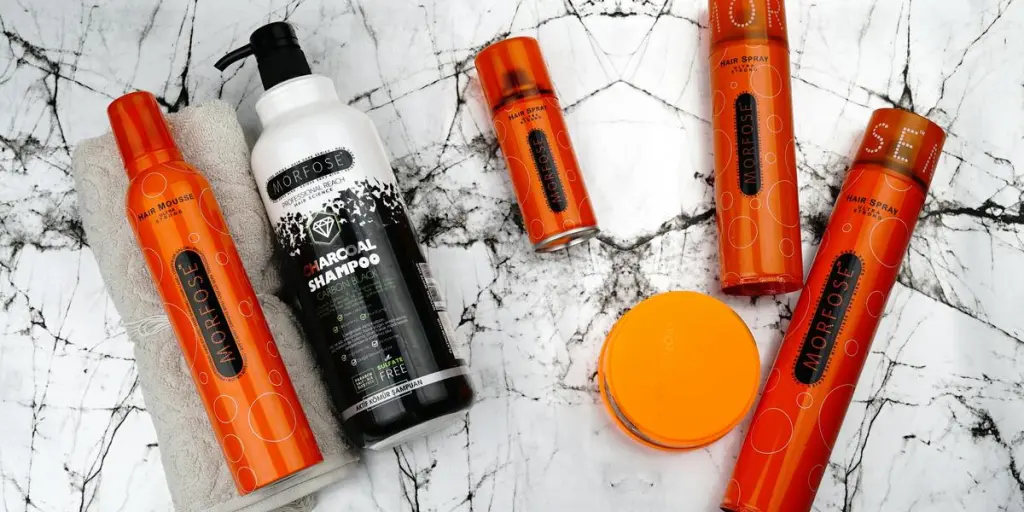 Flat lay of Morfose hair care products including mousse and charcoal shampoo on marble