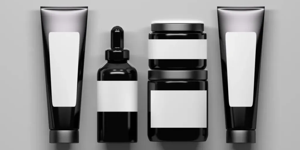 Flat lay with a set of black shiny cosmetics bottles packaging