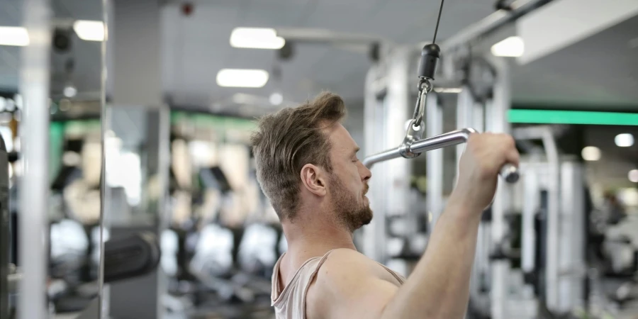 Focused man performing lat pulldown exercise indoors