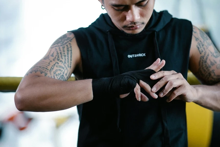 Focused martial artist wrapping his hands before training at the gym