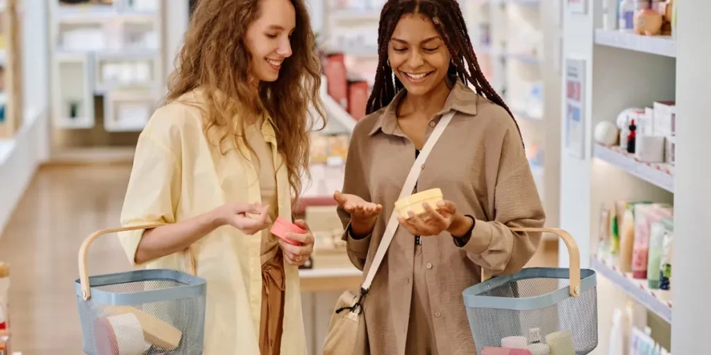 Girlfriends choosing cream together during their shopping in the cosmetics store