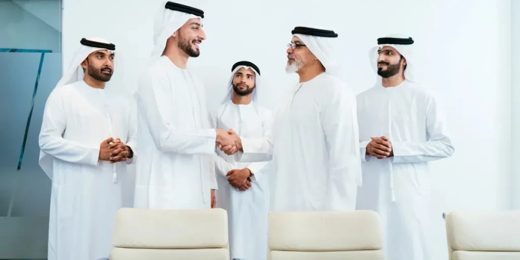 Group of corporate arab businessmen meeting in the office - Middle-eastern businesspeople wearing emirati kandora working in a meeting room