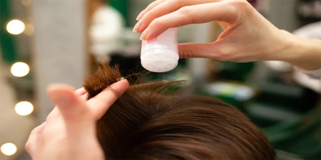 Hairdresser sprinkles the client's head with powdered hair