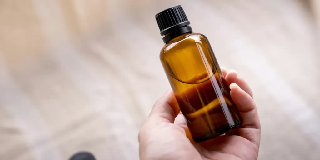 Hand holding amber glass bottle