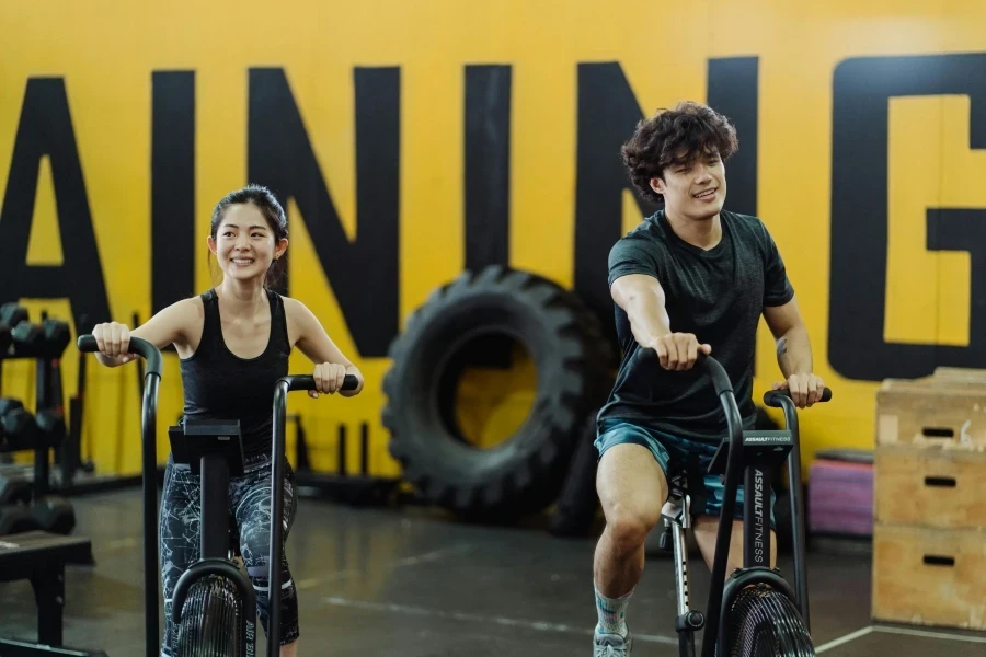 Happy couple enjoying an indoor cycling workout together, enhancing fitness and having fun