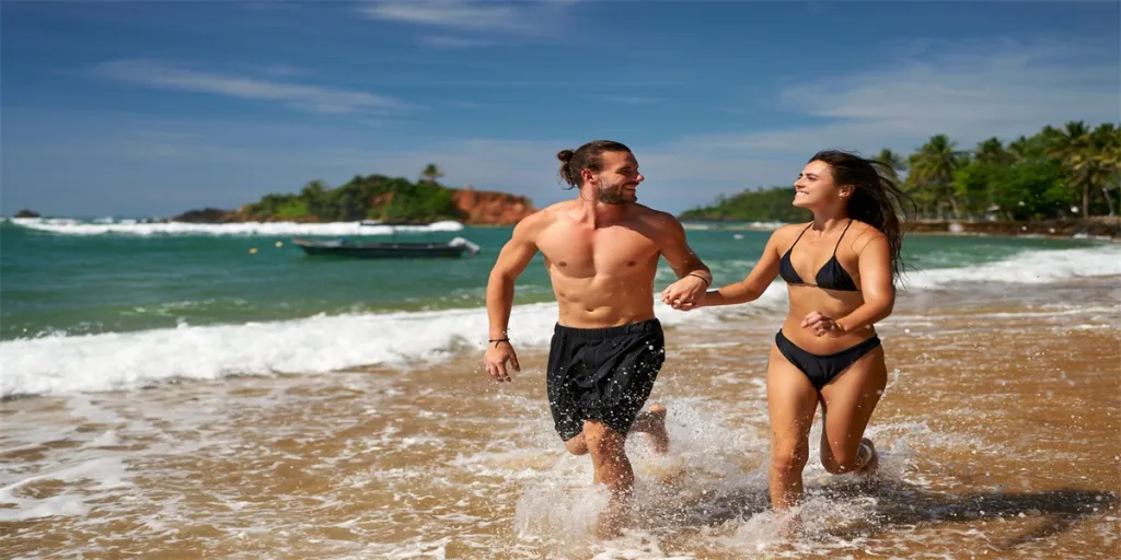 Joyful couple runs on tropical beach