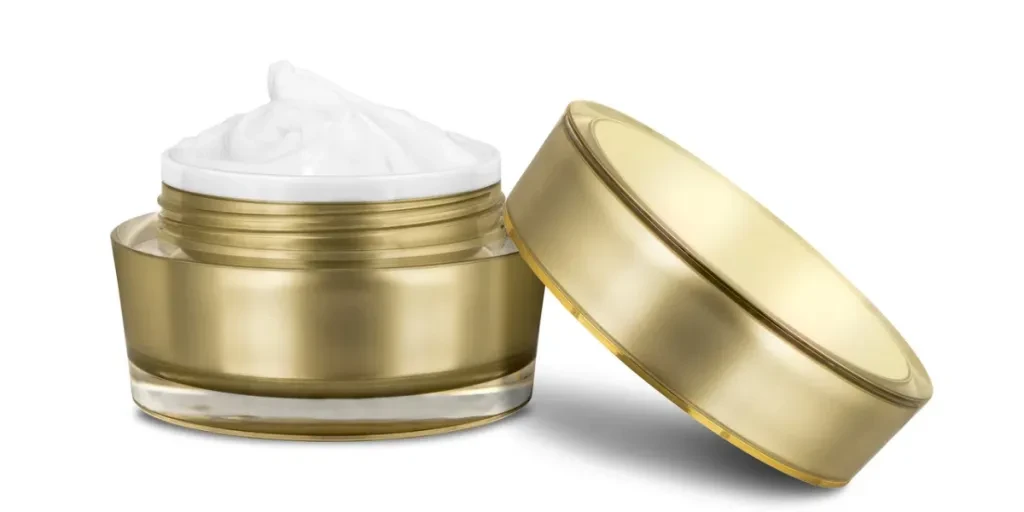 Luxury cosmetic face moisturizing smudged white cream for aged skin in open glossy golden can with matching lid