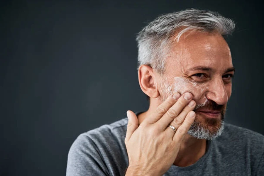 Man applying cream to areas where smile lines appear