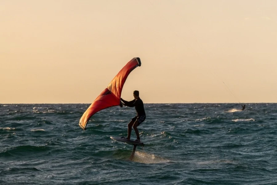 Man riding a hydrofoil kite board at sunset in Atlit