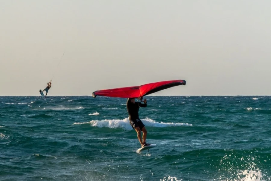 Man riding a hydrofoil kite board at sunset