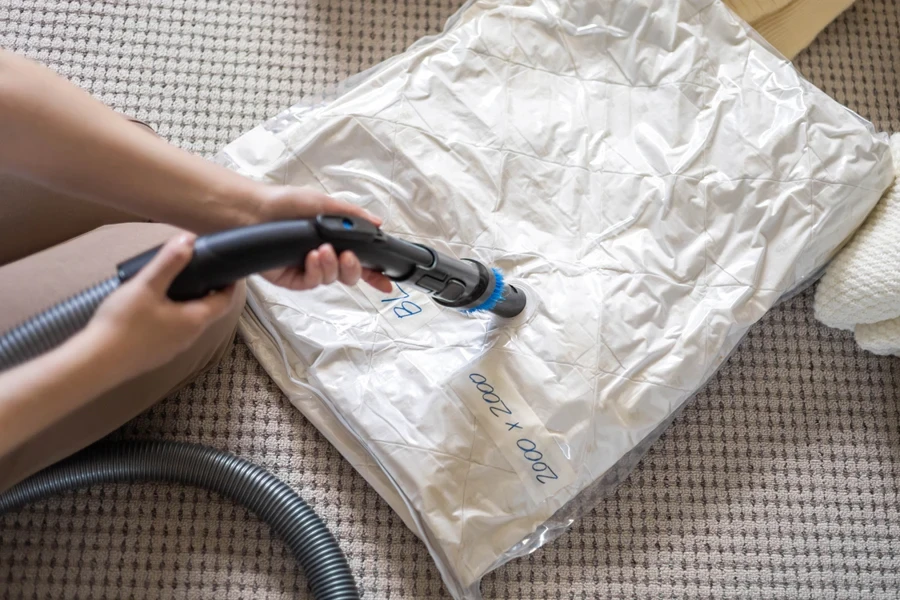 Man using a machine to suck air out of a vacuum storage bag