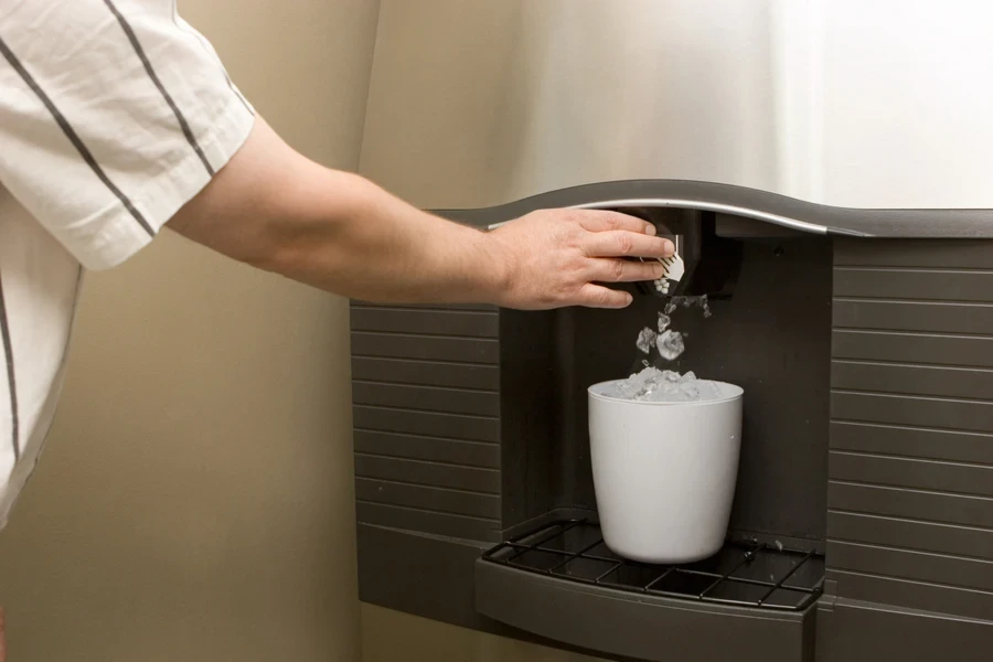 Man using an ice machine to fill a white tub