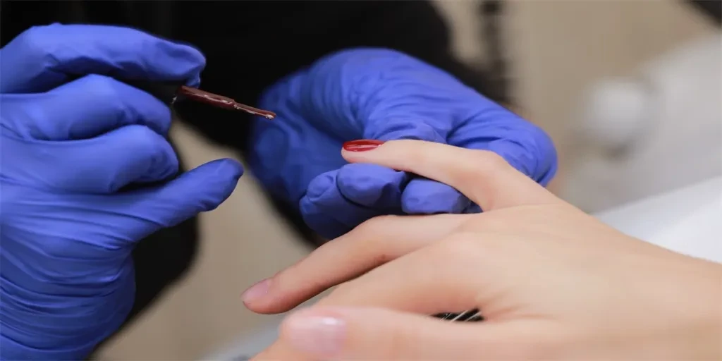 Master in protective gloves during a manicure at beauty salon