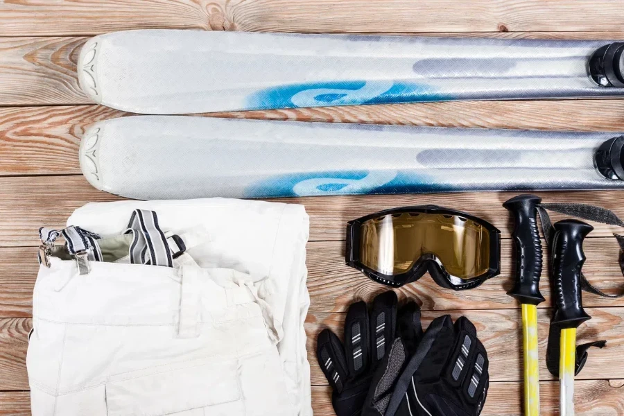 Overhead view of ski accessories placed on rustic wooden table