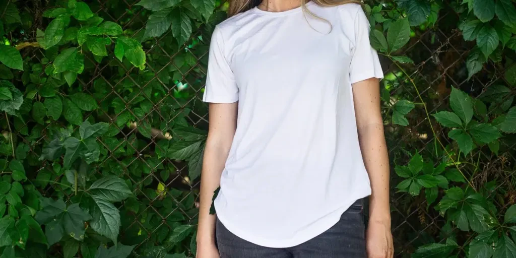 Person In A White Shirt Leaning Against A Vine Covered Fence