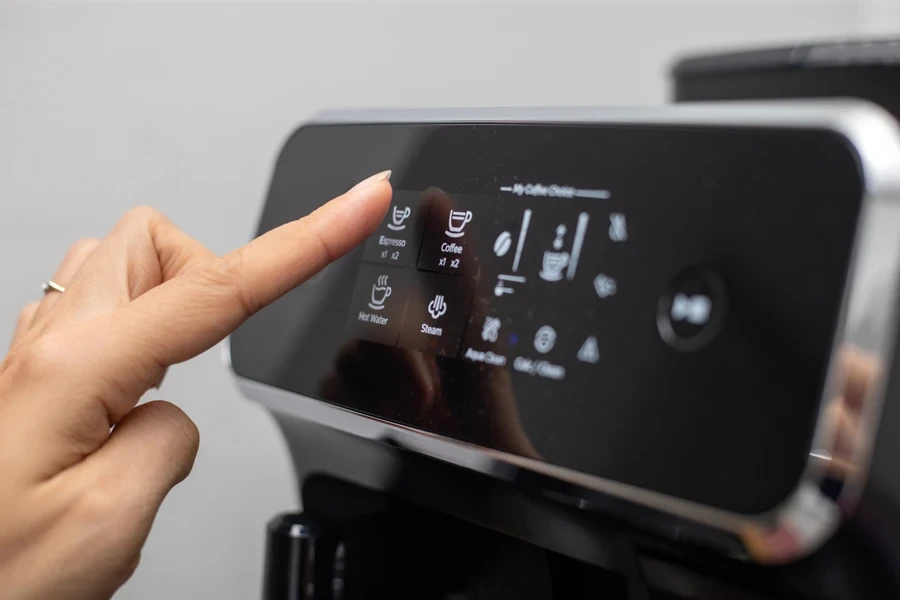 Person making a coffee with an automatic espresso machine