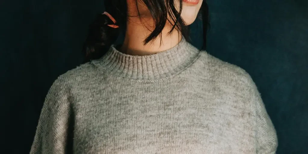 Persons Torso And Neck In A Grey Sweater