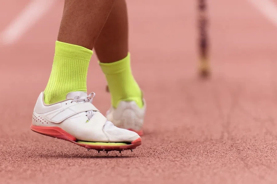 Pole vaulter prepares for jump, detail of sports shoes spikes