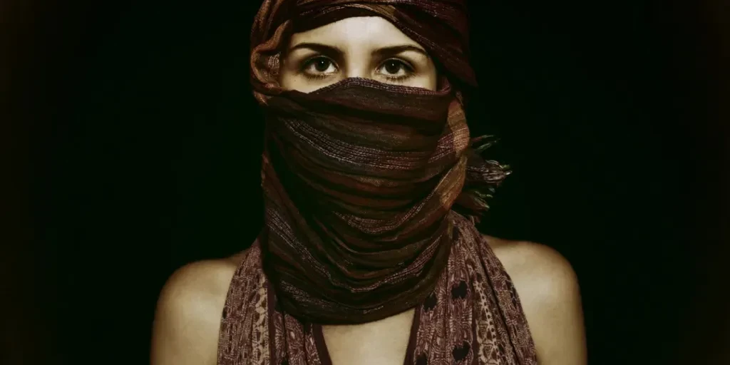 Portrait of beautiful green-eyed woman in hijab on black background