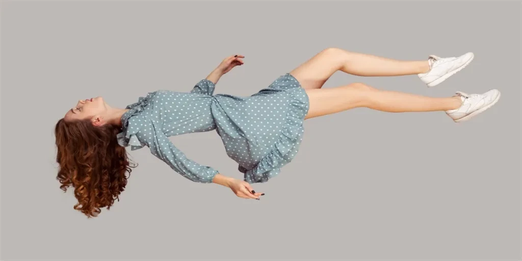 Relaxed girl in vintage ruffle dress levitating keeping eyes closed