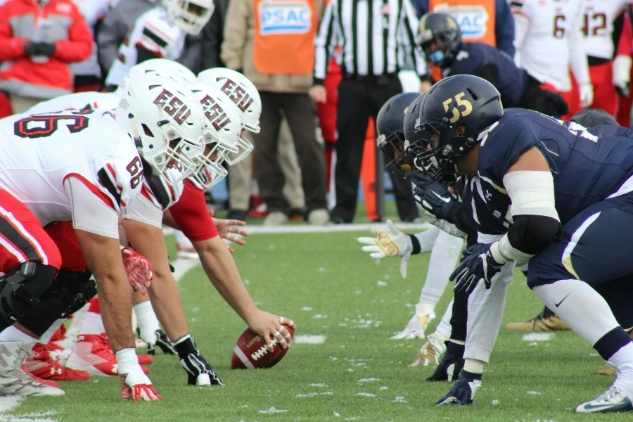 Rival football teams face off at the start of an action-packed game on the field