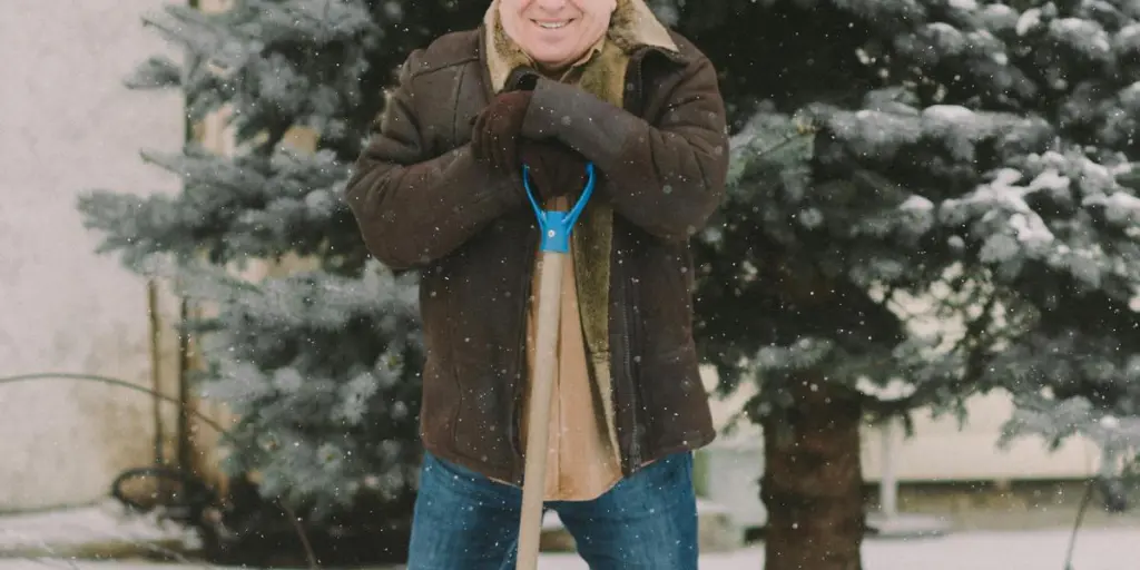 Senior adult shoveling snow in a snowy outdoor setting, winter clothing and evergreen tree