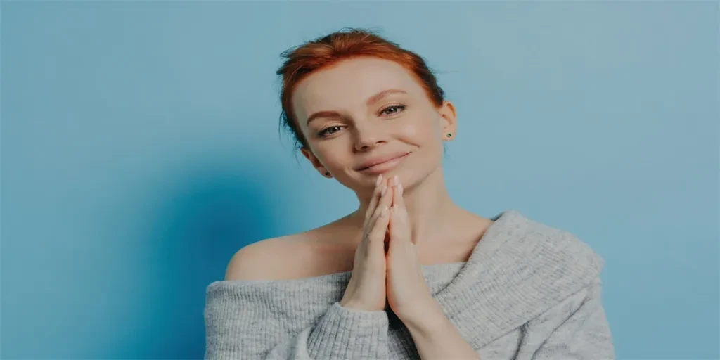 Serene redhead woman with hands together