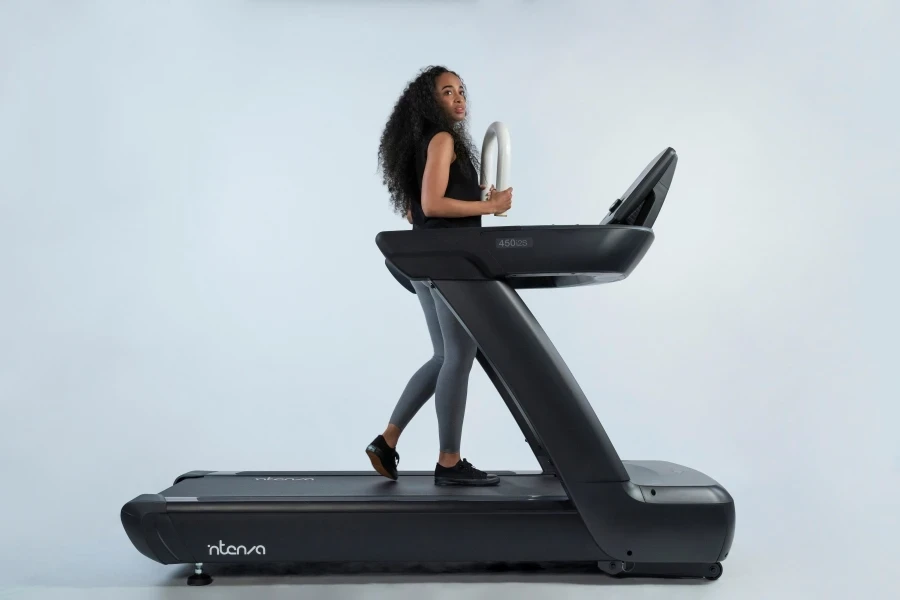 Side view of young fit girl using fitness accessory on Intenza 450 Series Treadmill