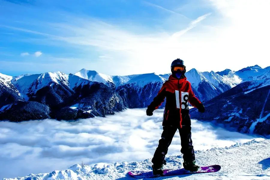 Snowboarder on snowy mountain with stunning cloud and peak views in Sachseln, Switzerland