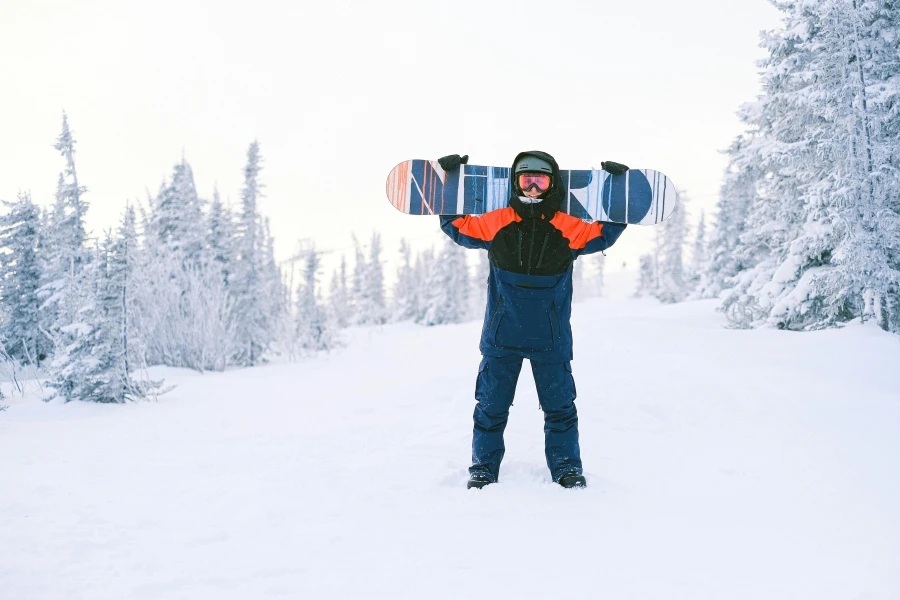 Snowboarder with arms raised on a snowy landscape, showcasing winter sports excitement