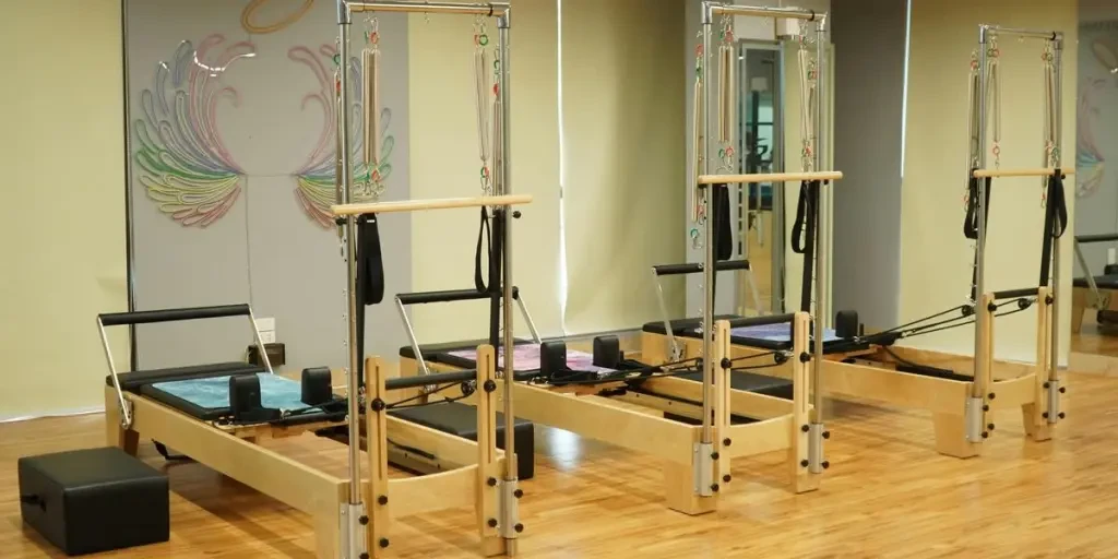 Spacious Pilates studio featuring wooden reformers and minimalistic decor