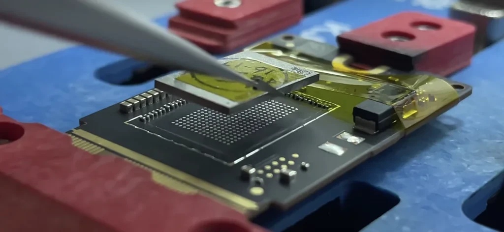 Technician replacing storage chips on Mac mini's storage board.