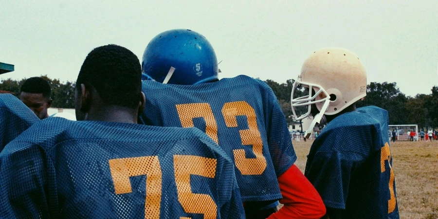 Teenagers in football gear during practice on a sports field