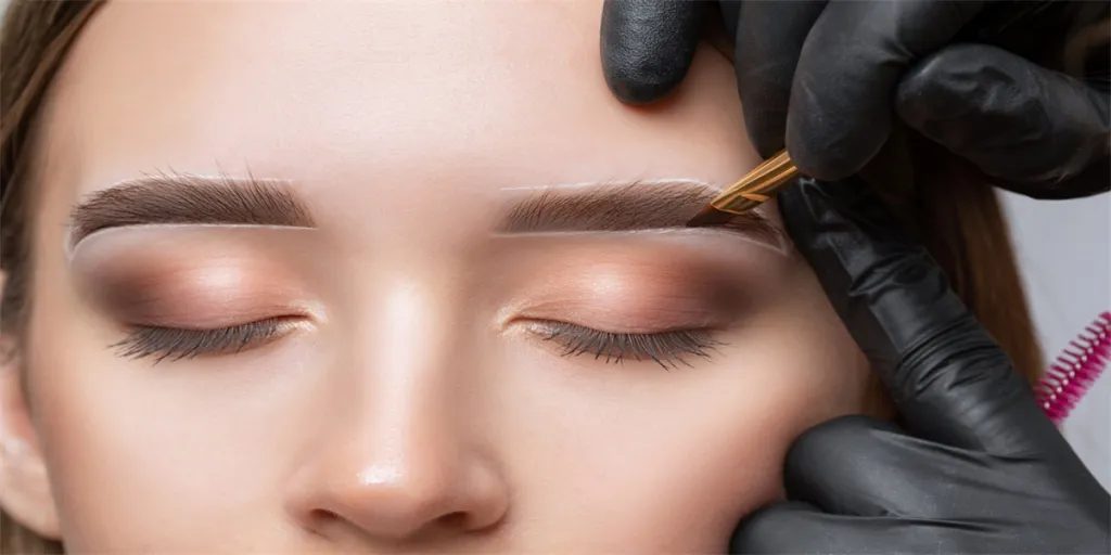 The make-up artist does Long-lasting styling of the eyebrows of the eyebrows and will color the eyebrows