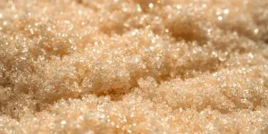 La textura de un exfoliante amarillo brillante sobre un fondo beige.