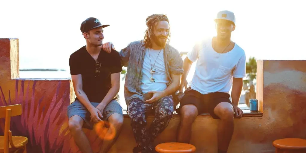 Three friends relax on a Tel Aviv rooftop, soaking up a vibrant sunset atmosphere