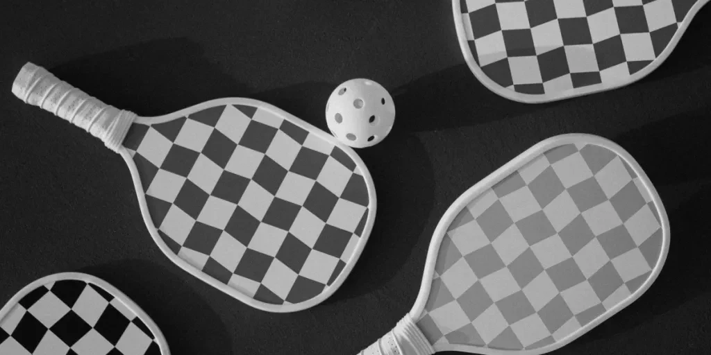 Top view of checkered paddles and balls on a dark surface, perfect for sports themes