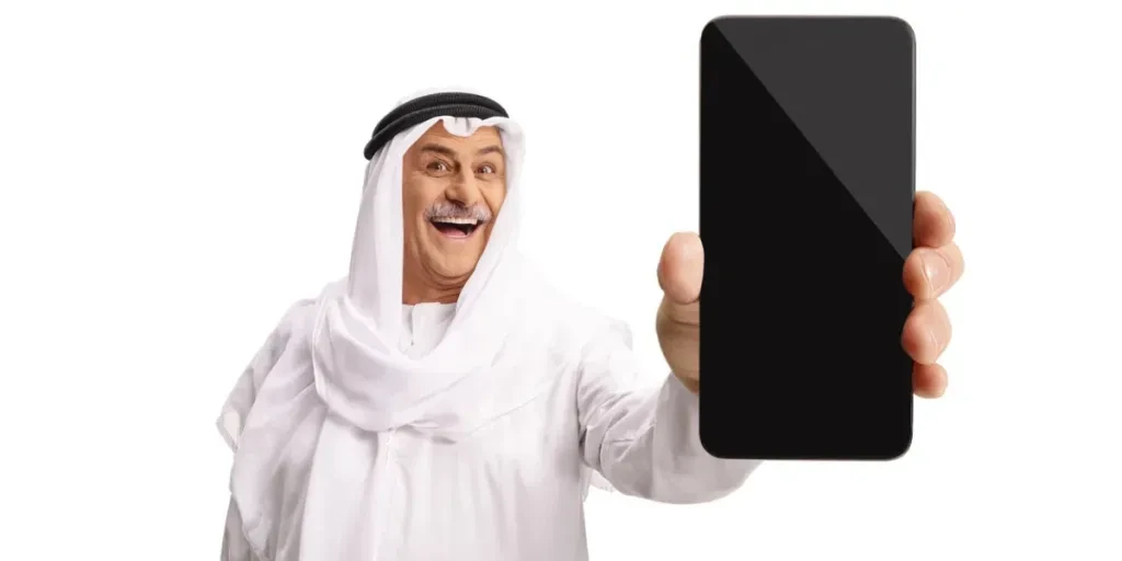 Traditional mature arab showing a smartphone isolated on white background