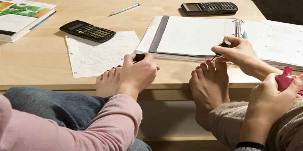 Two female students painting their toenails