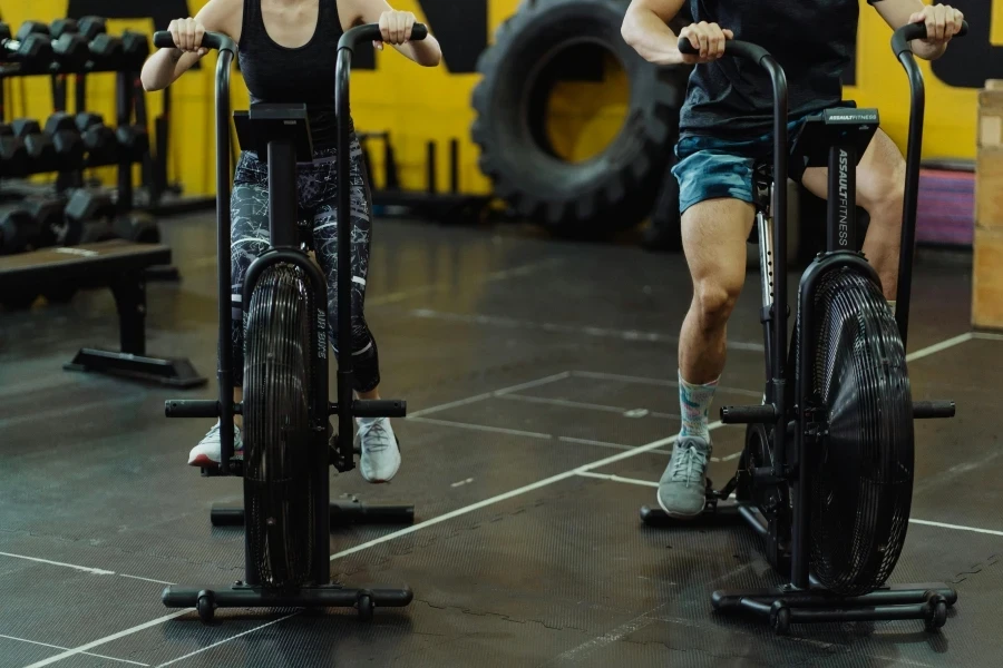 Two people exercising on stationary bikes at a modern gym