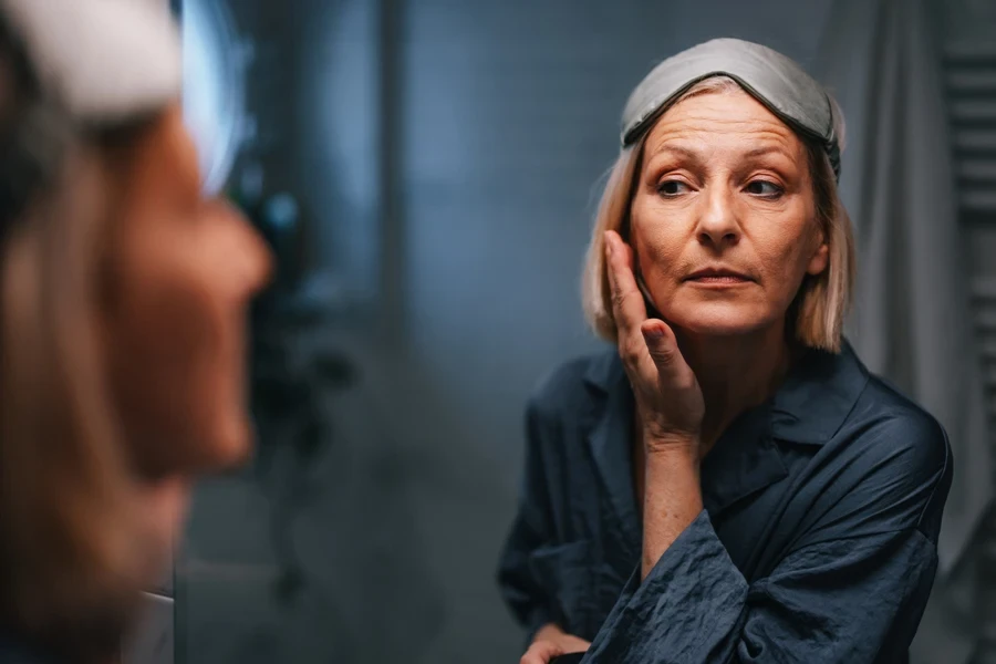 Woman applying facial cream in the evening