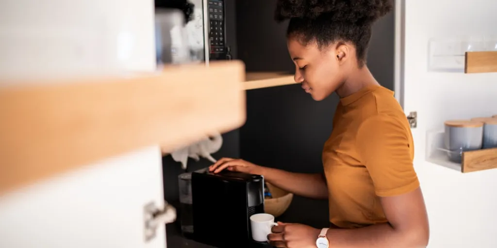 Woman brewing coffee with an automatic espresso machine